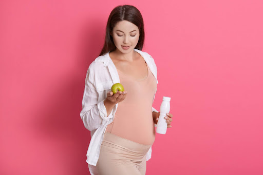 pregnant woman holding apple and water bottle can i go to the dentist while pregnant lee simon